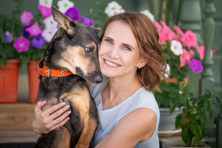 Portrait of a smiling girl hugging a big funny puppyの写真素材