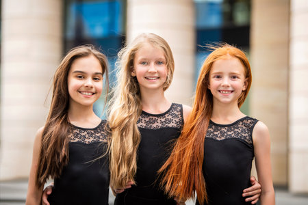 Portrait of three teenage girls with loose hair, blonde, redhead and brunette Summer on the street. Vloses develop in the wind.の写真素材