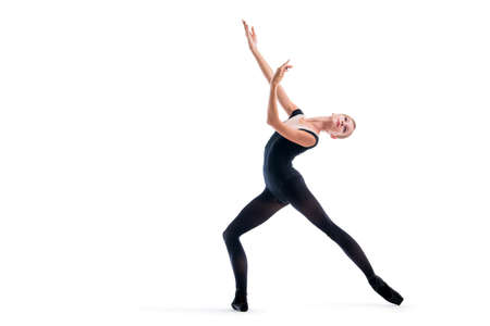 young ballerina in black pointe shoes and leotards posing in graceful pose, isolated on a white...