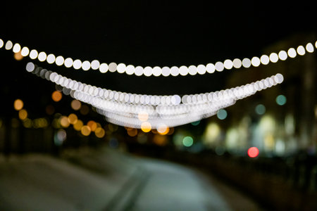 Abstract blurred background with colorful bokeh circles. Urban lifestyle background of street lights and garlands christmas in winterの写真素材