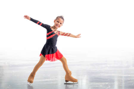 Little skater posing in red and black dress on ice isolated on white backgroundの写真素材