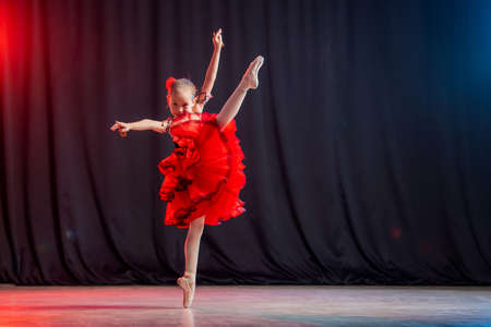 little girl ballerina is dancing on stage in tutu on pointe shoes with castanedas, the classic variation of Kitri.の写真素材
