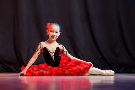 little girl ballerina is dancing on stage in tutu on pointe shoes with castanedas, the classic variation of Kitri.の写真素材