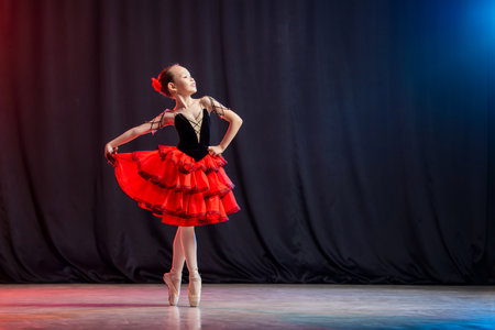 little girl ballerina is dancing on stage in tutu on pointe shoes with castanedas, the classic variation of Kitri.の写真素材