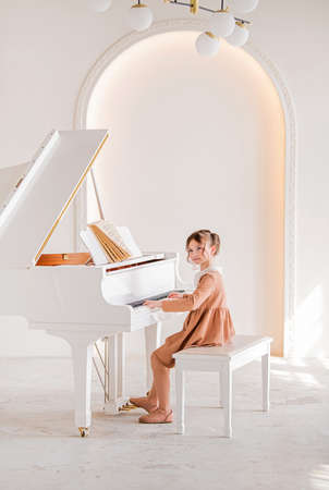 Little girl playing piano indoorsの写真素材
