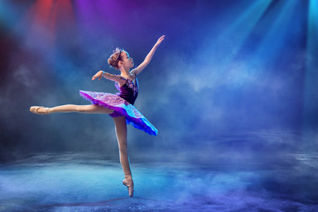 little Japanese ballerina dances on stage in a lilac tutu on pointe shoes classical ballet.の写真素材
