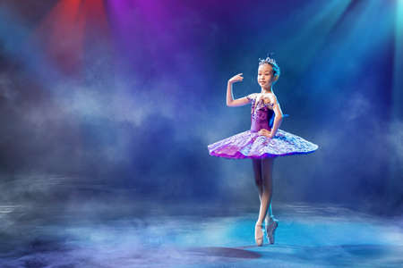 little Japanese ballerina dances on stage in a lilac tutu on pointe shoes classical ballet.の写真素材