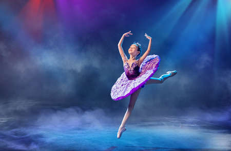 little Japanese ballerina dances on stage in a lilac tutu on pointe shoes classical ballet.の写真素材