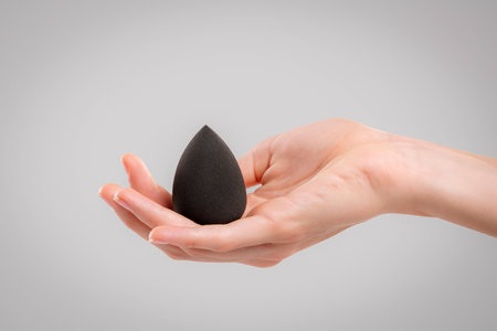 Hand with makeup sponges on white backgroundの写真素材