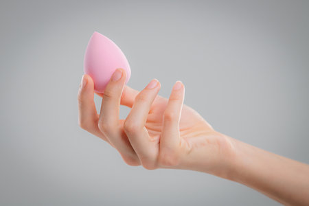 Hand with makeup sponges on white backgroundの写真素材