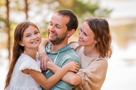 Portrait of a happy family in nature. Mom, dad and child.の写真素材