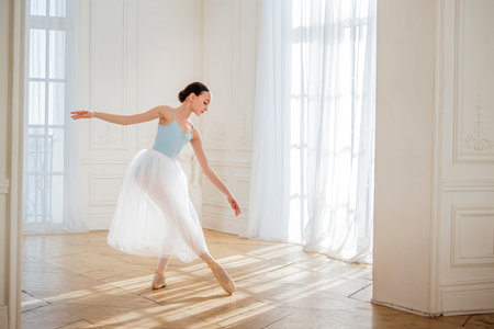 young ballerina is rehearsing in the studio. happy young ballerina exercising in the barre. Young...