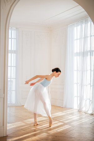 young ballerina is rehearsing in the studio. happy young ballerina exercising in the barre. Young pretty ballet dancer.の写真素材