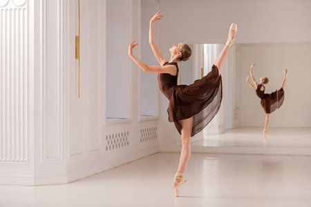 Ballet dancer gracefully executes a pirouette pose in a dance studio. The dancer's expression of focus and elegance highlights the beauty and discipline of ballet techniqueの写真素材