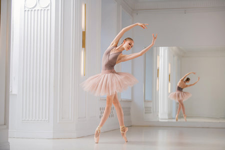 ballerina performs a graceful dance in a rehearsal studio, demonstrating posture and elegance. The dancer wears a flowing tutu and pointe shoes.の写真素材