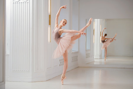 ballerina performs a graceful dance in a rehearsal studio, demonstrating posture and elegance. The dancer wears a flowing tutu and pointe shoes.の写真素材