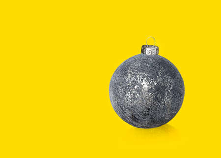 gray shiny christmas ball on yellow backgroundの写真素材