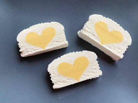 three rectangles of vanilla ice cream with yellow mango hearts on a gray background, top view, flat lay. high quality photoの写真素材