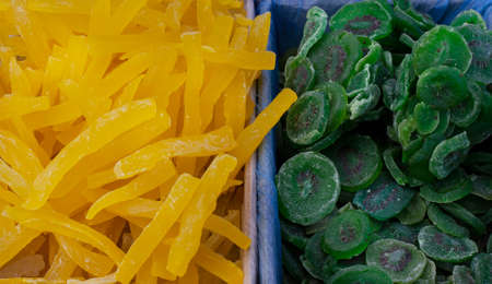 Dried fruits melon, kiwi, and a pile of candied slices in boxes at the market.の写真素材