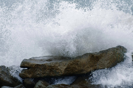 Storm on the coast. The waves hit the rocks and create foam.