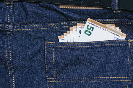 Euro banknotes in the back pocket of blue jeans close-upの写真素材
