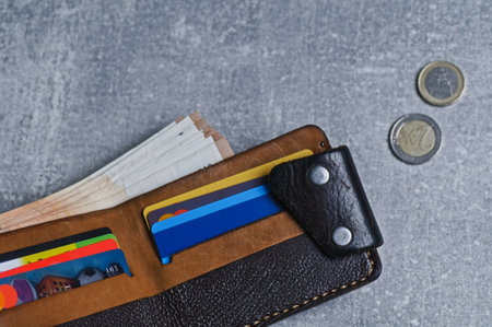 Wallet with credit cards and coins on a gray background. top view