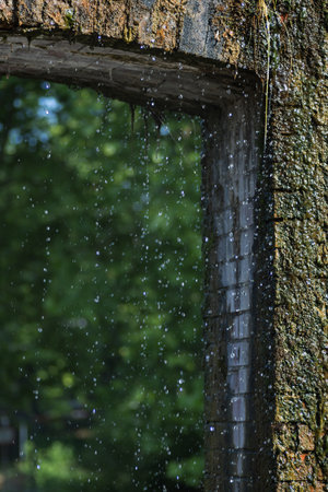Raindrops on the window of an old building in the village.の写真素材