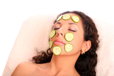 woman with a cucumber mask on the face over white backgroundの写真素材