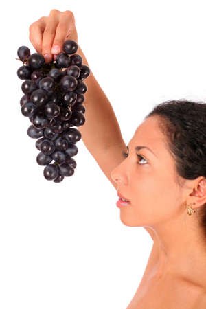 A woman holds a bunch of dark grape in her hand, standing on white backround. の写真素材