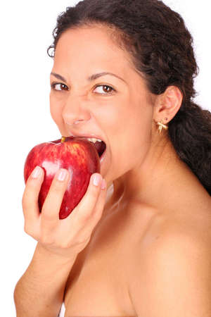 A woman eats red apple, standing on white background.の写真素材