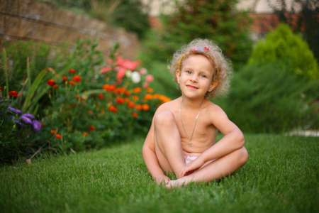 A little girl sitting on the grassの写真素材