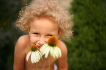 A little girl having fun among the flowersの写真素材