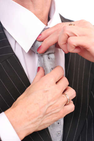 A businesswoman touching her tie over white blackgroundの写真素材