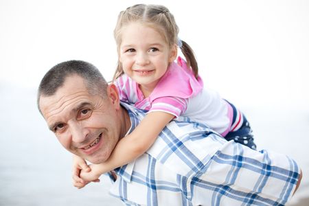 Outdoor portrait of middle-aged smiling man and his granddaughterの写真素材