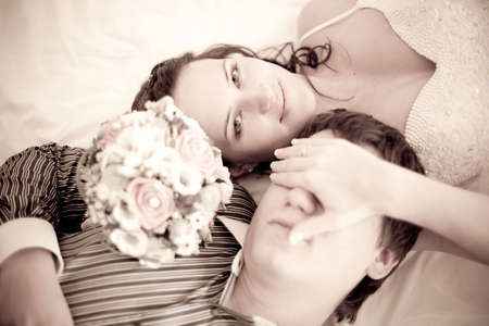 Portrait of an attractive bride and a groom which are lying on the bedの写真素材
