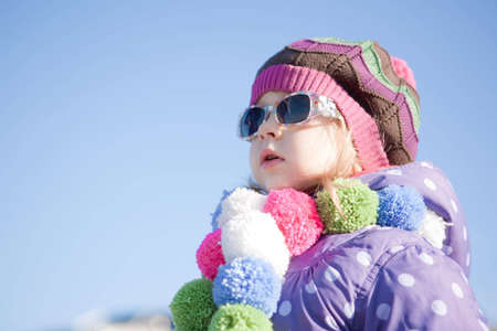 Portrait of a cute girl in a bright warm clotherの写真素材