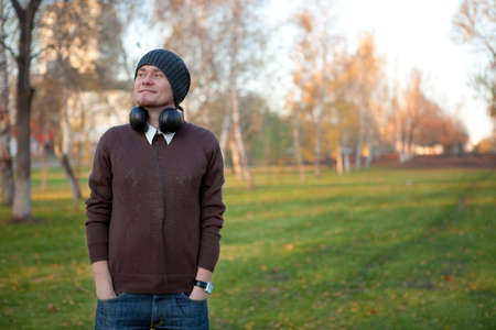 Portrait of a handsome man with earphones in the parkの写真素材