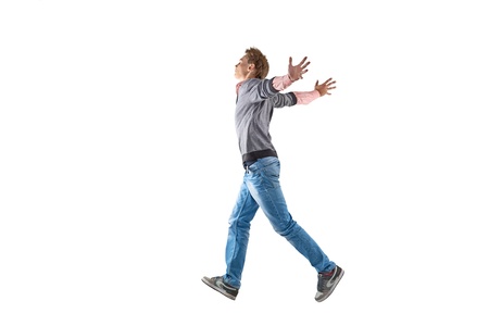 Young man is jumping over white backgroundの写真素材