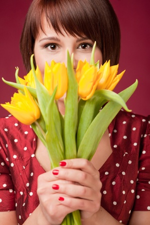 Happy woman is holding a bunch og tulipsの写真素材