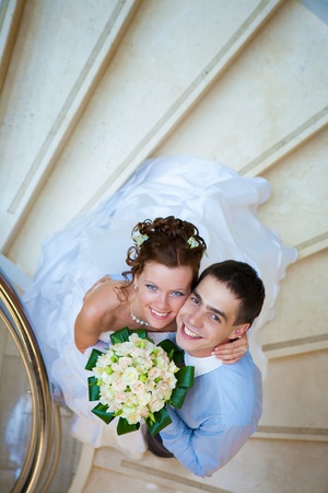 Happy bride and groom is standing on the stairsの写真素材