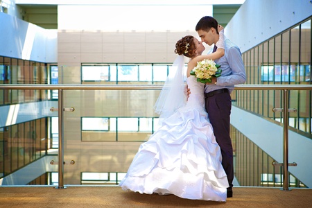Happy bride and groom is standing in the hotelの写真素材