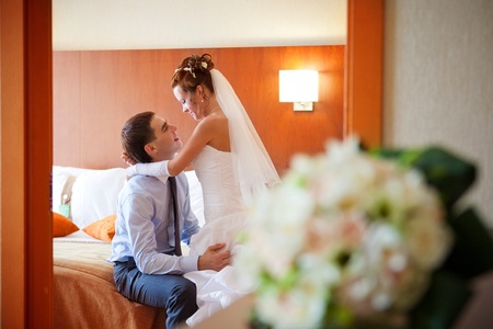 Newlywed couple romancing in the bedroomの写真素材