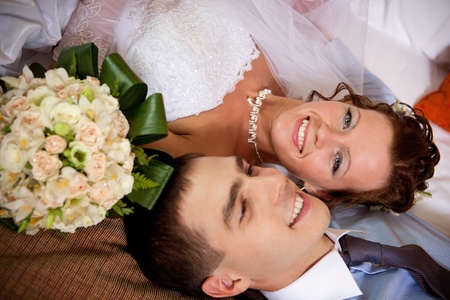 Newlywed couple lying together on the bedの写真素材