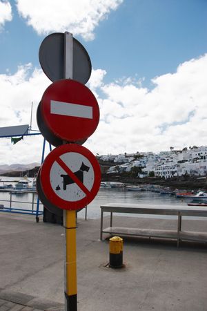 sign posts overlooking an old lanzarote harbourの写真素材