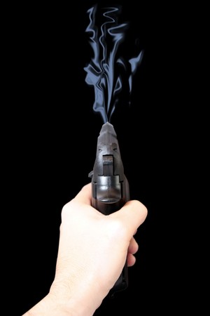 a gun being shot against a black background の写真素材