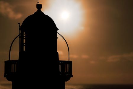 silhoutte of lighthouse captured with the sun behind itの写真素材