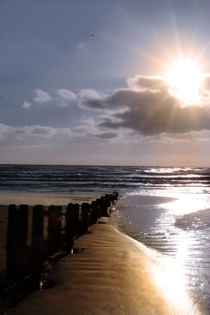 wave breakers at sunset on a beach in youghal county cork irelandの写真素材