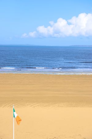 a view of the beach in ballybunion co kerry ireland with irish flagの写真素材