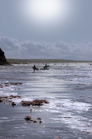 surfers in the storm waves crashing in on ballybunion beach ireland