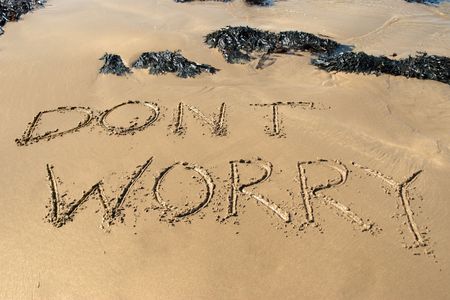 dont worry inscribed on the beach with waves in the background on a hot sunny dayの写真素材
